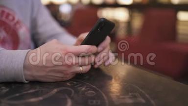 一位年轻的商人坐在咖啡馆的桌子旁，用<strong>iphone</strong>和<strong>短信</strong>打字——成功人士，每天